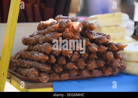 Dolci tradizionali della Churchkhela georgiana, realizzati con corde di noci immerse in succo d'uva concentrato e addensato in una bancarella di mercato a Tbilisi, Georgia Foto Stock