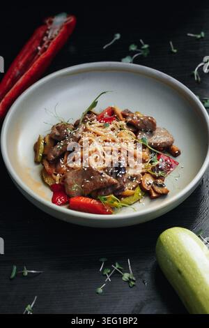 Colorato piatto di spaghetti di ispirazione asiatica servito in una ciotola bianca Foto Stock