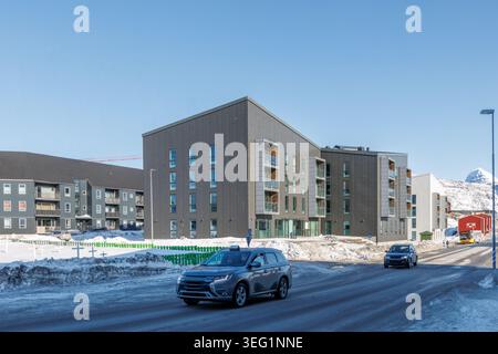 Moderni edifici residenziali groenlandesi con auto su una strada ghiacciata invernale, Nuuk, Sermersooq, Groenlandia Foto Stock
