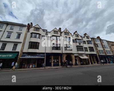 Vecchi edifici storici in una strada di Oxford, Inghilterra. Vista degli edifici di High Street a Oxford. Gente che cammina lungo la strada Foto Stock