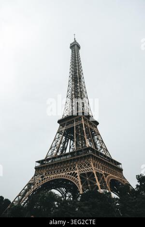 La Torre Eiffel, un simbolo iconico di Parigi, si erge maestosamente contro un cielo nuvoloso, mostrando la sua bellezza architettonica in mezzo alla vibrante città Foto Stock