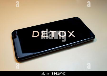 Parola detox scritta con lettere di legno su uno schermo dello smartphone spento, sul concetto detox digitale beige Foto Stock