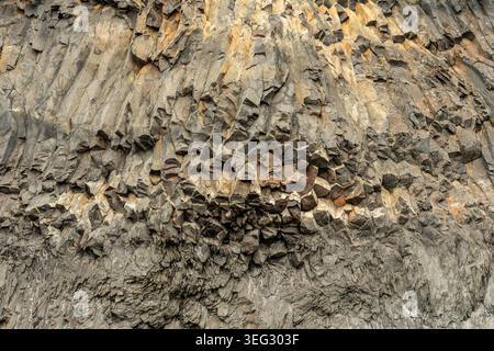 Colonne di basalto, pilastri naturali di roccia vulcanica indurita, famose per le loro forme geometriche, spesso esagonali coperte da muschio sulla Reynisfjara Foto Stock