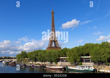 La Torre Eiffel sorge sopra le case galleggianti ormeggiate lungo la Senna a Parigi, in Francia. Foto Stock