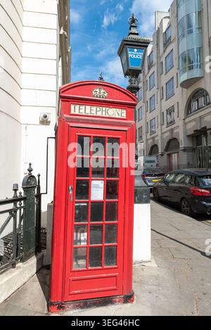 Iconica cabina telefonica rossa vicino alla stazione di polizia di Charing Cross, a Charing Cross, Westminster, Londra, Regno Unito, con una lanterna della polizia d'epoca Foto Stock