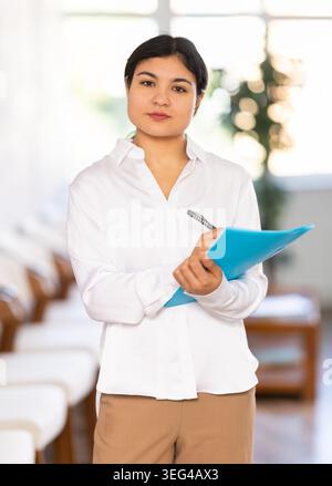 Ritratto di una receptionist cortese con cartella Foto Stock