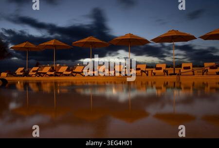 Cancun, Messico - 15 gennaio 2026: Sdraio e ombrelloni con riflesso in piscina presso un resort a Cancun, Messico, in una mattina d'inverno. Foto Stock