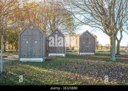 Capannoni in legno nel parco, piccole capanne in legno scuro su erba, concetto di stoccaggio all'aperto, Copenhagen Foto Stock