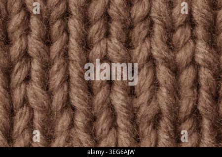 Vista dettagliata di un tessuto lavorato a mano spesso e sfocato in una tonalità marrone brillante, che mostra l'intricato motivo di cucitura e le fibre fuzzy Foto Stock