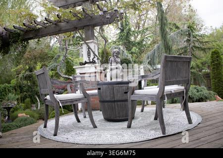 Area salotto rustica all'aperto sotto Pergola Foto Stock