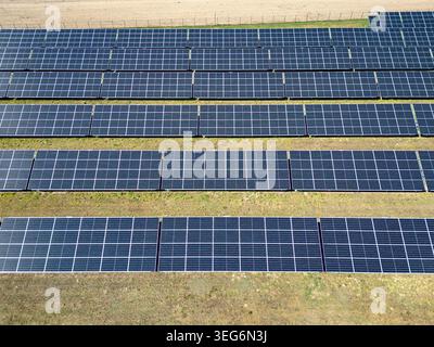 Vista aerea dall'alto verso il basso di file di pannelli solari fotovoltaici nella regione polacca di Mazowsze Foto Stock