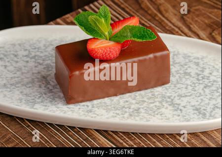 Mousse glassata al cioccolato con fragole e menta Foto Stock