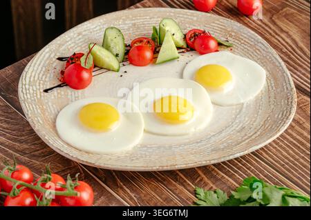 Uova fritte placcate con verdure fresche per colazione Foto Stock