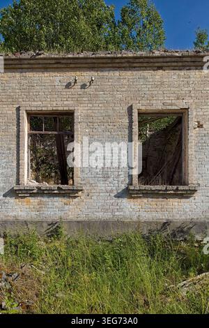 Edificio in rovina e abbandonato situato in un sito militare ex sovietico, ora sopraffatto dalla natura, Saaremaa, Estonia, Europa. Foto Stock