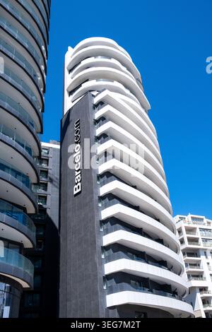 Vista ad angolo basso dei moderni e alti edifici di appartamenti con balconi sovrapposti, facciate curve e un cielo azzurro limpido a Sliema, Malta, 5 agosto 2025. TH Foto Stock