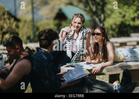 Gli amici del college studiano e si rilassano all'aperto nel campus, trascorrendo una giornata di sole insieme Foto Stock