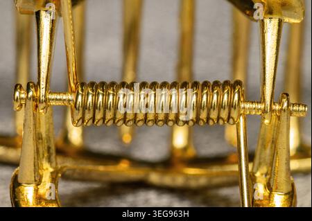 Primo piano di un meccanismo a molla dorato lucido con dettagli intricati Foto Stock