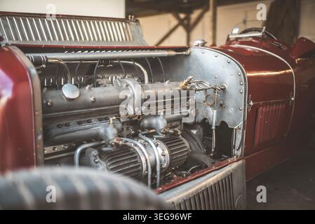 Questa foto dettagliata mostra il potente motore di una classica auto da corsa d'epoca, evidenziandone il design e i componenti complessi Foto Stock