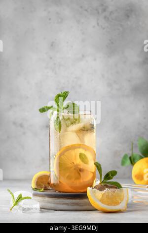Tè al limone ghiacciato in vetro su sfondo grigio con spazio di testo. Concetto di bevanda fresca e rinfrescante estiva Foto Stock