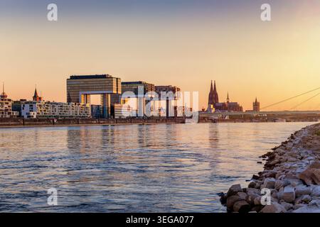 Vista panoramica dello skyline di Colonia, in Germania, dalle rive del Reno fino alla cattedrale durante l'alba dorata Foto Stock