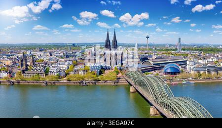 Vista panoramica del paesaggio urbano di Colonia, Germania, lungo il fiume Reno dalla città vecchia all'iconica cattedrale durante una soleggiata giornata estiva Foto Stock