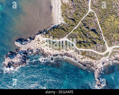 Questa splendida fotografia aerea cattura la bellezza serena di un paesaggio costiero caratterizzato da acque turchesi cristalline e coste rocciose. L'immagine viene mostrata Foto Stock