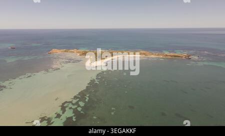 Splendida ripresa aerea che cattura la bellezza serena di una piccola isola circondata da acque turchesi cristalline. L'immagine evidenzia la spiaggia sabbiosa, Foto Stock