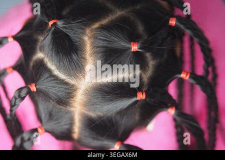 Capelli intrecciati brillanti con fasce colorate Foto Stock