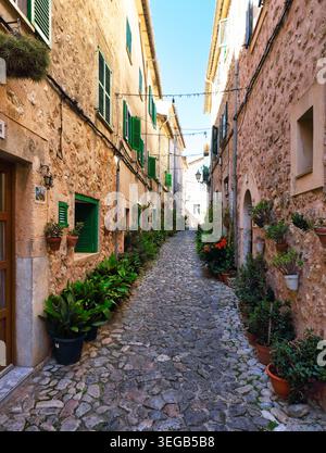Stretta strada del paese con fiori a Valldemossa a Maiorca, Spagna Foto Stock