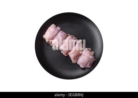 Cibo, filetti di coscia di pollo crudi freschi con sale, spezie ed erbe aromatiche su sfondo di cemento scuro Foto Stock
