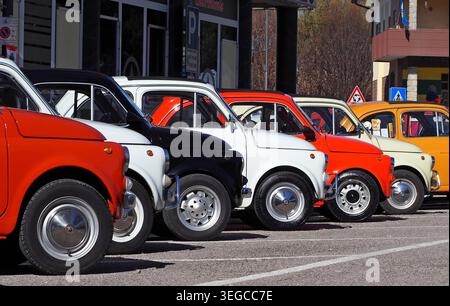 Percoto, Italia. 24 marzo 2019. Una fila di colorate Fiat 500 S d'epoca in un parcheggio lungo la strada durante un raduno di auto d'epoca. Foto Stock