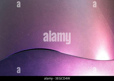 Pannello della carrozzeria ricurvo che divide lo spazio tra vernice metallizzata viola e magenta con finitura lucida e riflessi speculari brillanti Foto Stock