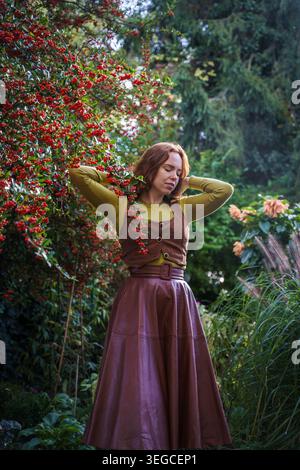 Giovane donna che pratica Mindfulness vicino a Red Autumn Berries Foto Stock