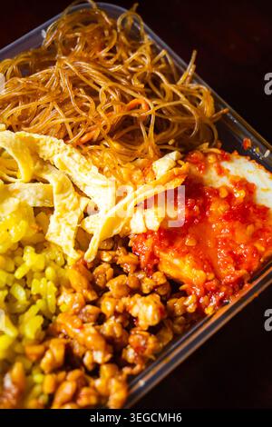 Nasi Kuning, riso curcuma indonesiano cotto con latte di cocco e spezie aromatiche Foto Stock