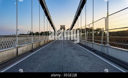 Vista del ponte sospeso di Clifton con la sua iconica torre in pietra e i cavi sospesi sotto un cielo limpido al crepuscolo Bristol, Regno Unito. Foto Stock