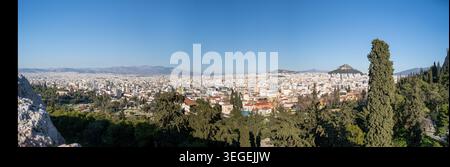 Un'ampia vista panoramica dell'estesa città di Atene, Grecia, che mostra il suo fitto paesaggio urbano con l'iconica collina dell'Acropoli visibile nel dist Foto Stock