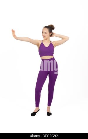Giovane donna graziosa che esegue una posa di danza classica in studio Foto Stock