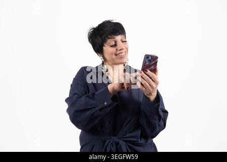 Allegra donna matura che digita sulla fotocamera sorridente dello smartphone mobile Foto Stock