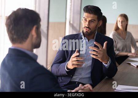 Due colleghi di sesso maschile che discutono della strategia aziendale in ufficio Foto Stock