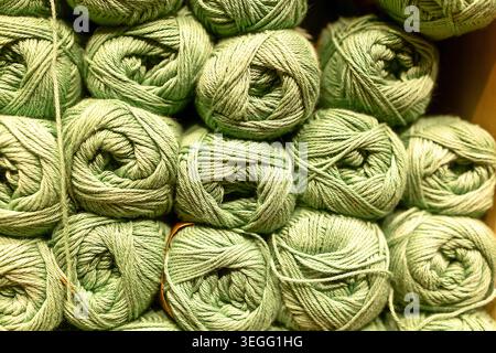 Consistenza di palline impilate di filato verde chiaro da vicino. Foto Stock