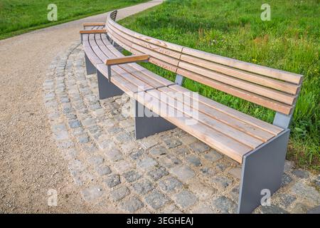 Moderna panca vuota in legno in un parco Foto Stock