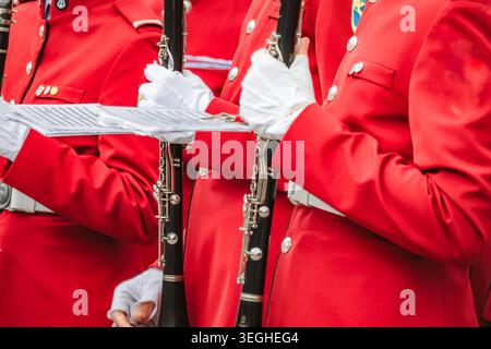 Sezione media di un ragazzo irriconoscibile che suona la tromba durante le prove dell'orchestra scolastica in classe Foto Stock