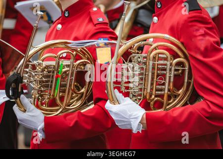 Sezione media di un ragazzo irriconoscibile che suona la tromba durante le prove dell'orchestra scolastica in classe Foto Stock