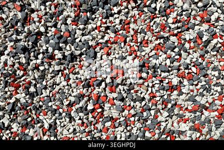 Ciottoli decorativi utilizzati nel giardino o nel cortile. Quelle in bianco e nero sono naturali e quelle rosse sono dipinte. Sfondo e consistenza Foto Stock