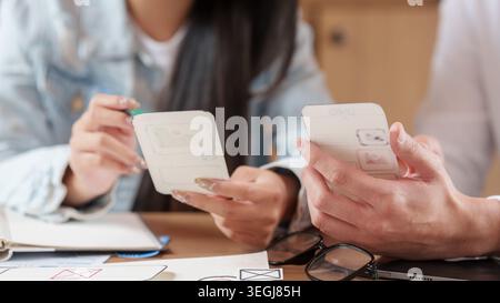 Progettisti che collaborano alla prototipazione di applicazioni mobili e all'esperienza utente Foto Stock