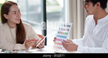 Designer asiatici che collaborano alla tavolozza dei colori in un ufficio moderno Foto Stock