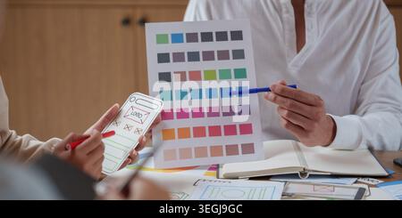 Designer asiatici dell'interfaccia utente utente che collaborano al branding delle applicazioni mobili e alla tavolozza dei colori. Foto Stock