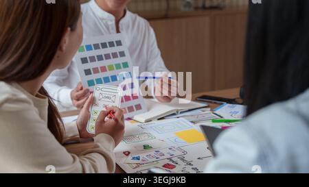 Designer asiatici dell'interfaccia utente utente che collaborano al branding delle applicazioni mobili e alla tavolozza dei colori. Foto Stock