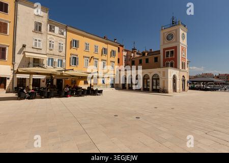 Torre dell'orologio e caffetteria all'aperto nella piazza principale di Rovigno, in Croazia, in una giornata di sole. Foto Stock