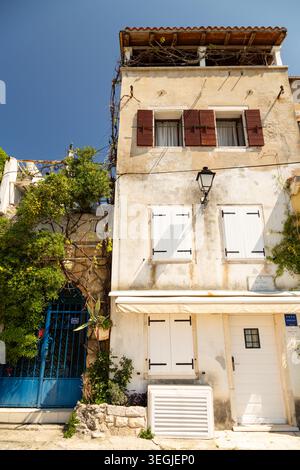 Edificio residenziale a tre piani con persiane e cancello blu in ferro battuto nella città vecchia di Rovigno, Croazia. Foto Stock